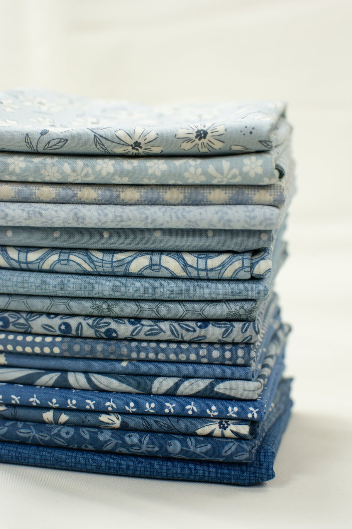 Blue Skies fat quarters for the Shine So Bright quilt kit, stacked from light to dark blue
